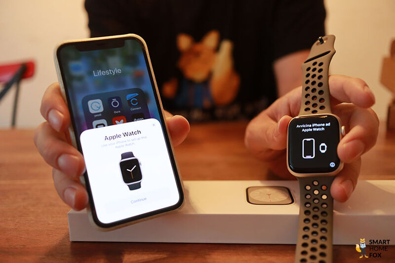 Man sieht die Apple Watch 8 Damen Smartwatch neben einem iPhone.
